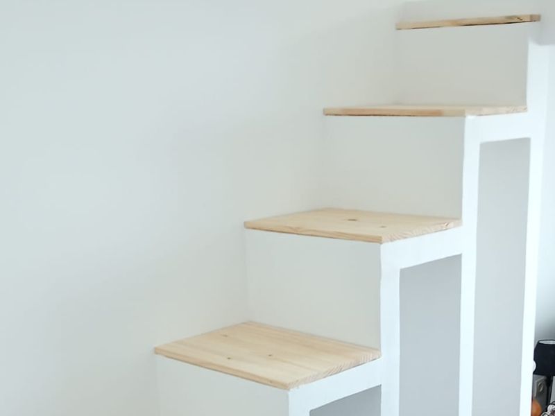 Escalier blanc aux marches en bois clair.