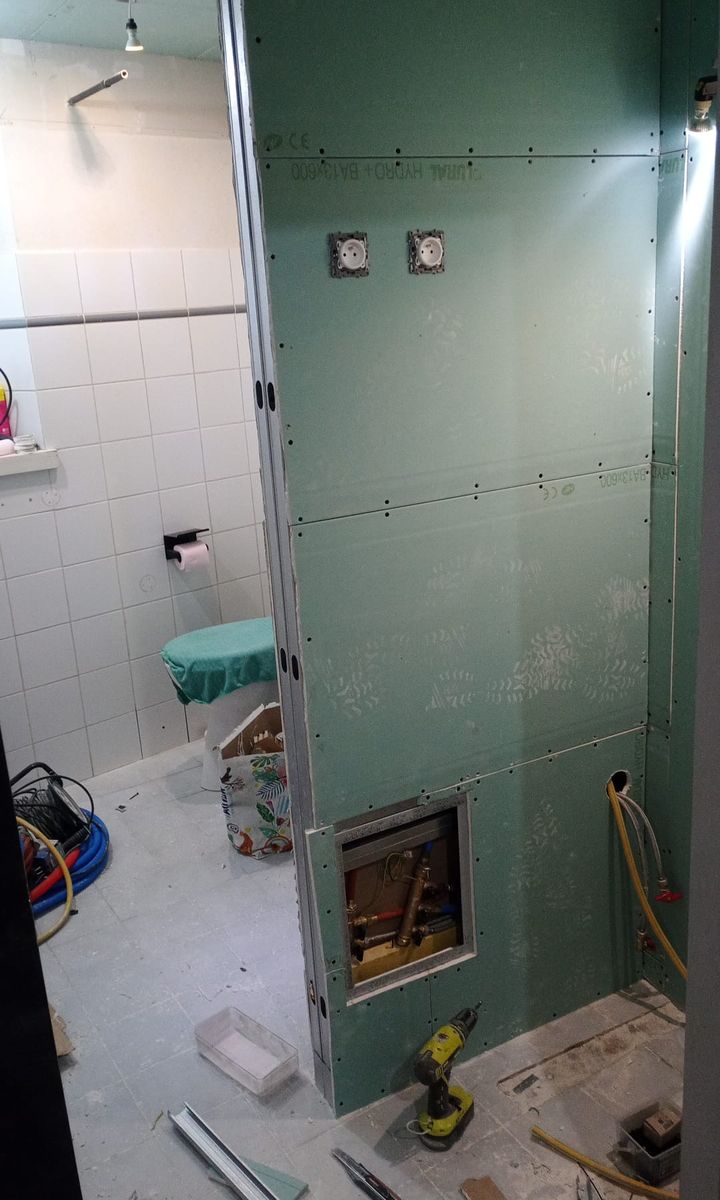 Plaques de plâtre hydrofuges posées dans une salle de bains, avec une trappe de visite.